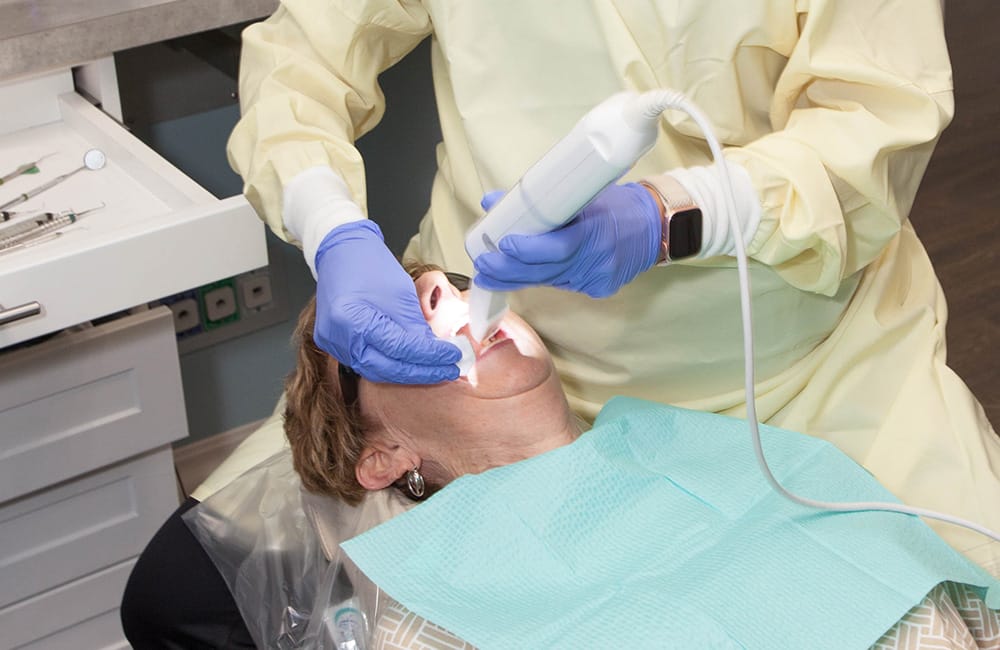 Dentist using a digital scanner to capture images of a patient's teeth